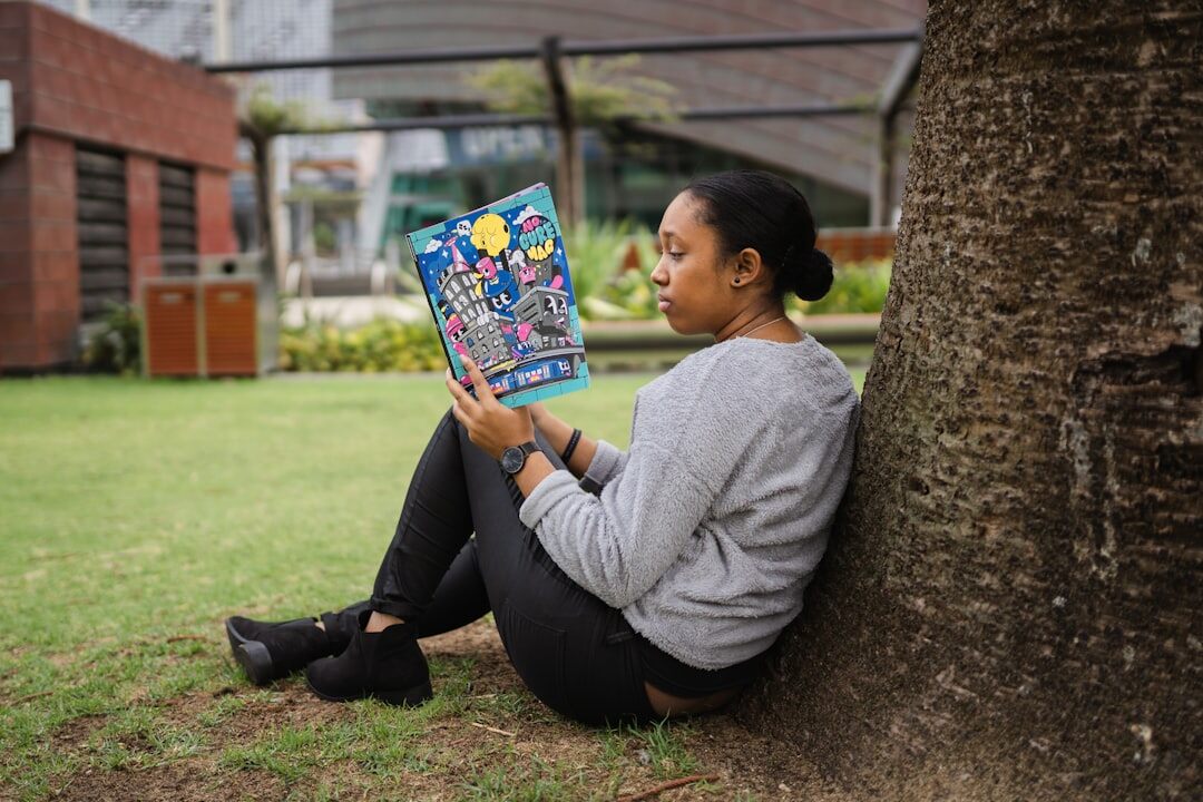 person reading book in park